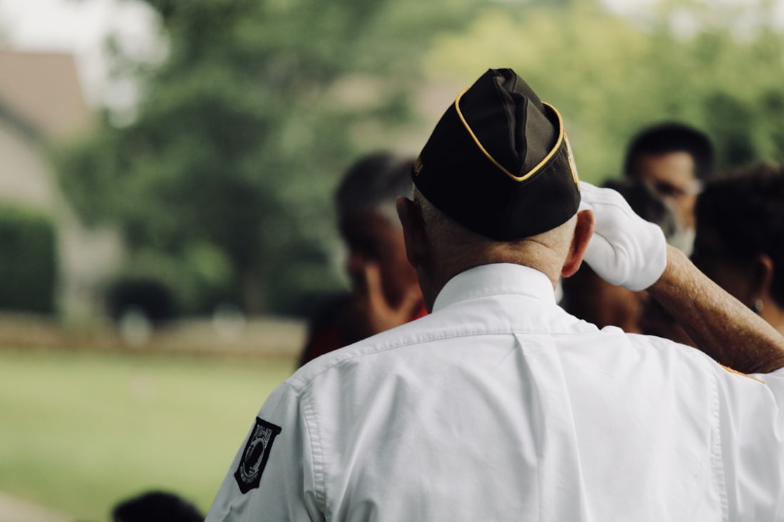 A veteran in uniform saluting during a ceremony